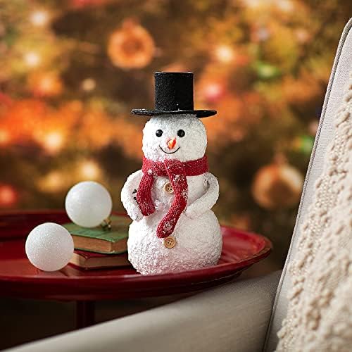 Pequeno boneco de neve de Natal com lenço de malha e decoração de mesa